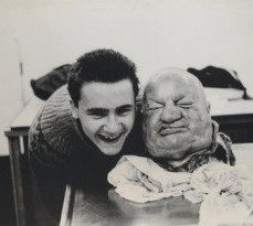 A young Damien Hirst holding a head in a morgue